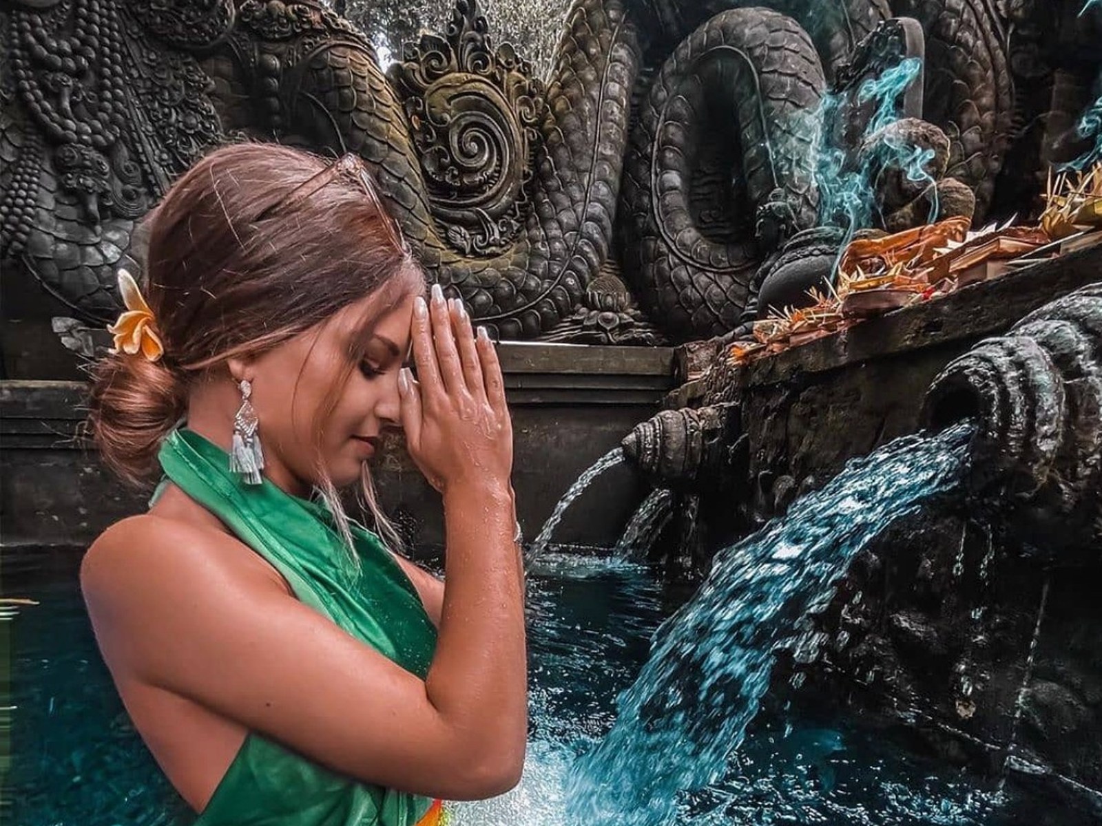 Woman in prayer at a sacred water spring at a Balinese temple