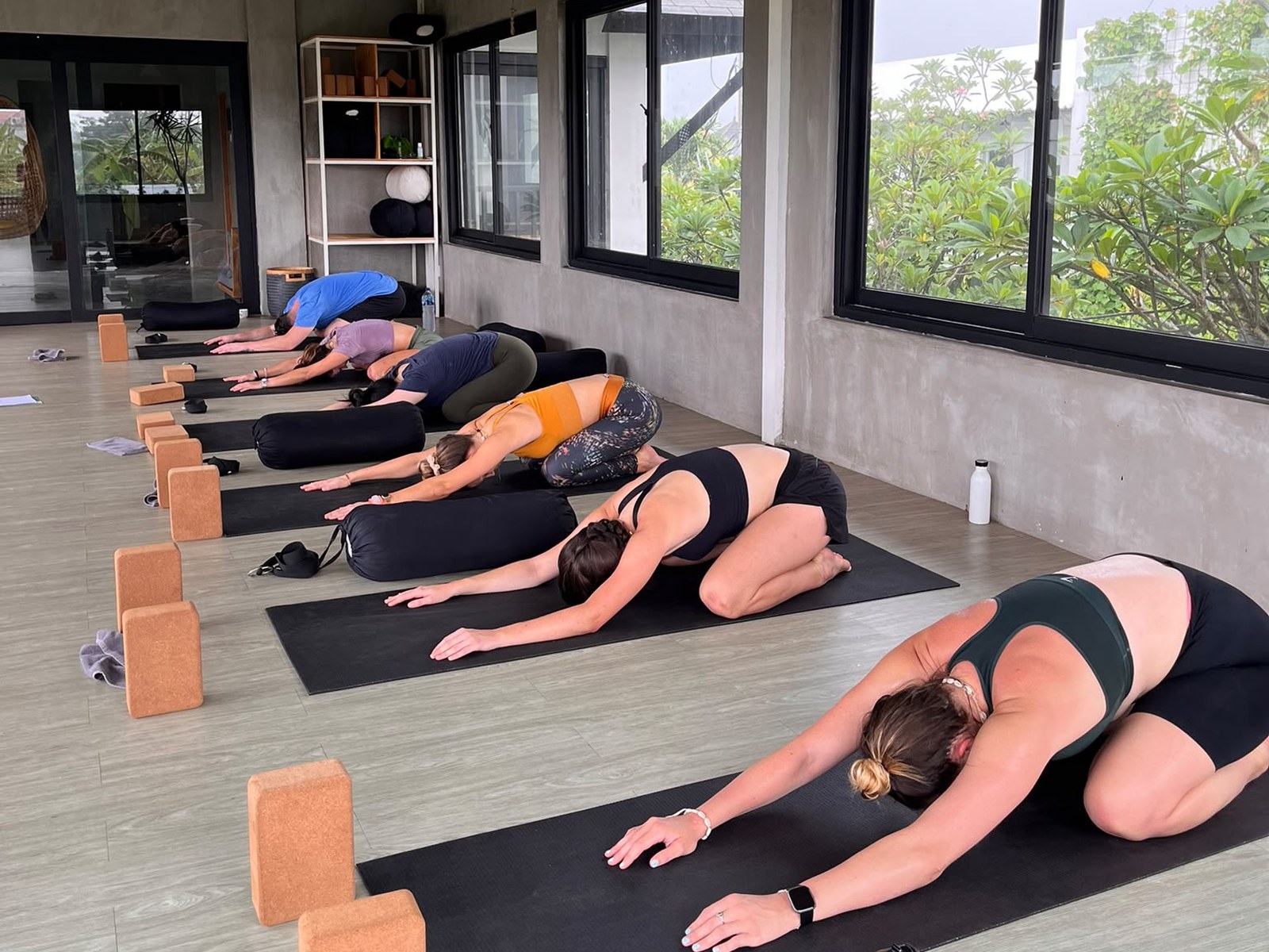 Guests resting in child's pose on mats in an open studio