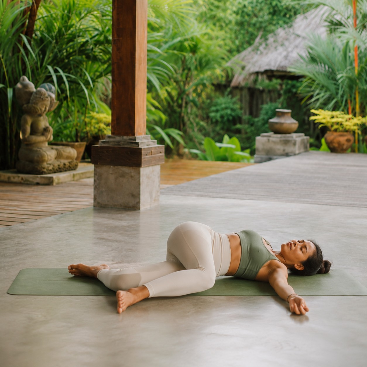 Woman in a supported bridge pose easing lower back tension on a yoga mat in Bali